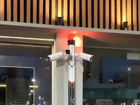 Poste Sentinela da Bismarck em frente a uma fachada comercial de vidro, à noite
